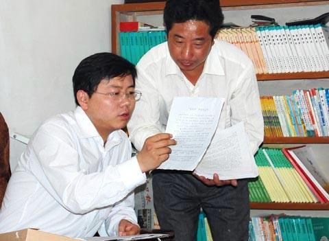 周森锋(左)向村干部询问娃娃菜经营模式 资料图
